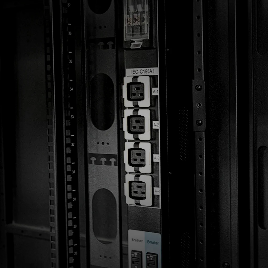The readout panel of a unit on the test bench, glowing with abstract metering glyphs, held in the left of the frame with the dark bench surface to its right