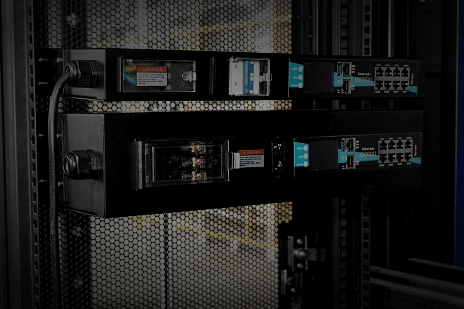 Inspection bench and test station on the assembly floor, a rack PDU chassis connected for a powered test in the right of the frame under one raking light